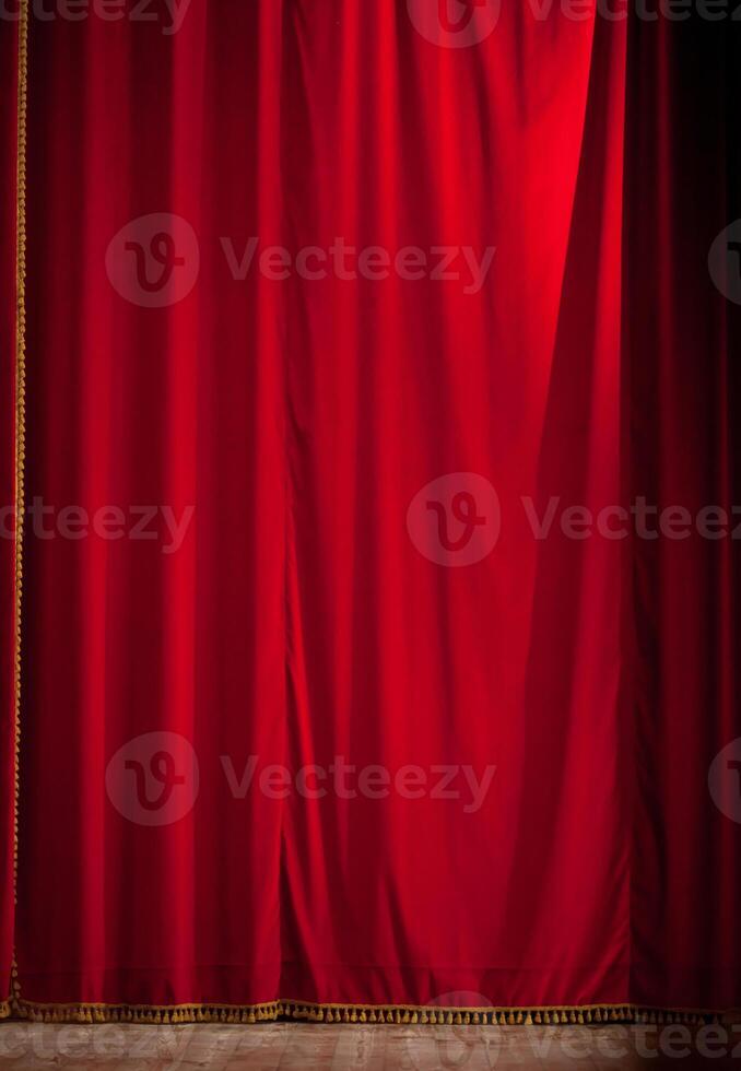 A red curtain is open in front of a wooden floor photo