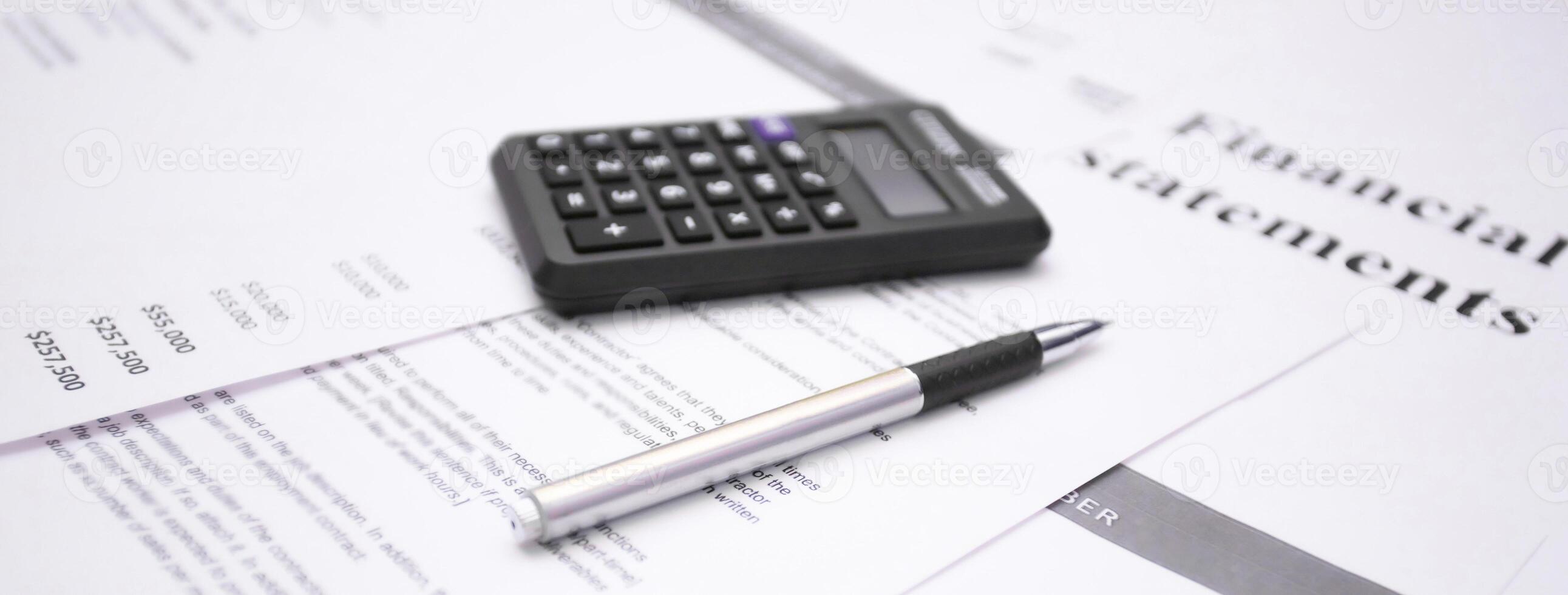Financial statement review with calculator and pen emphasizing numbers and data analysis photo