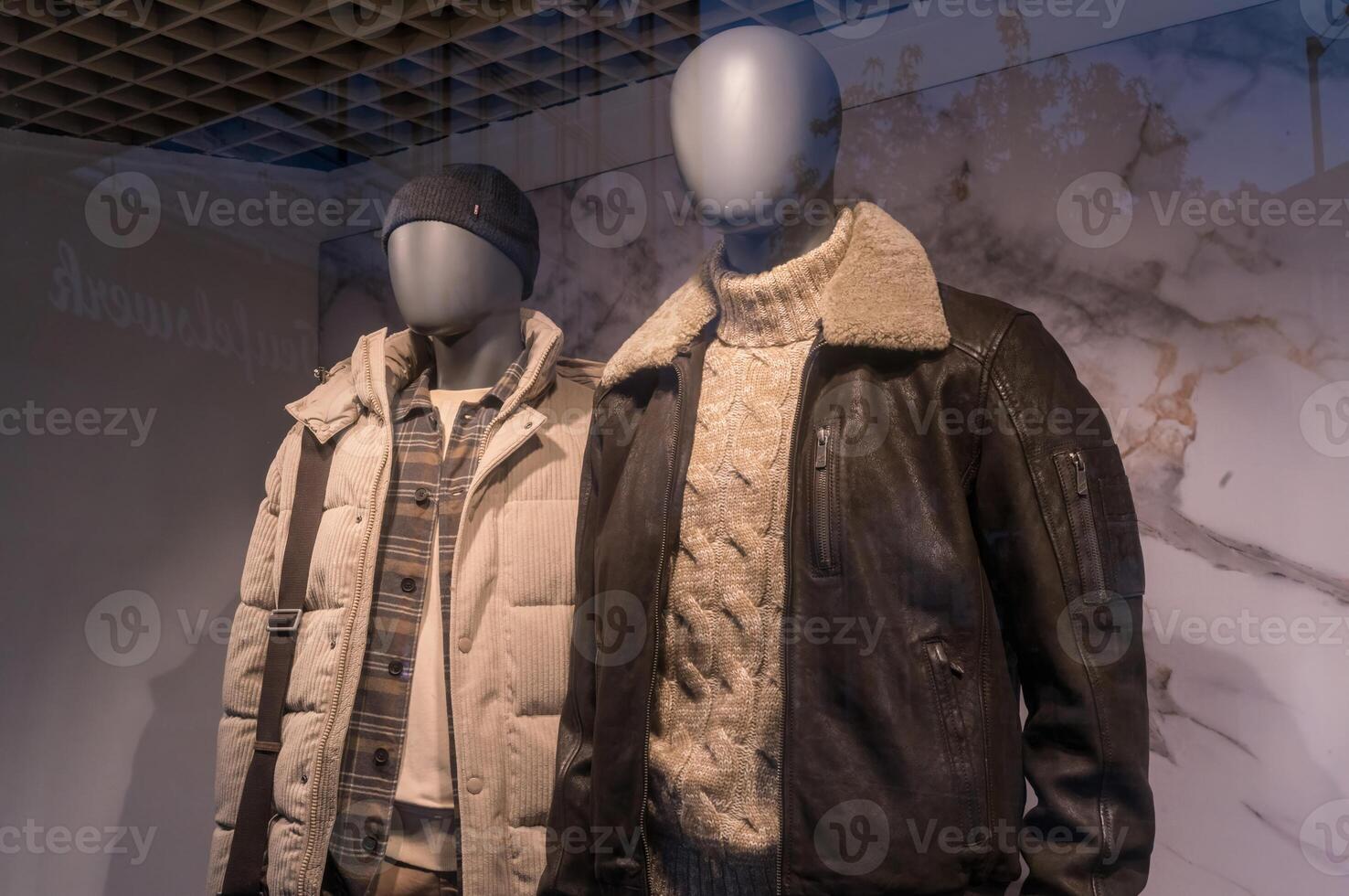 Mannequins wearing winter jackets and sweater in a fashion retail store display photo