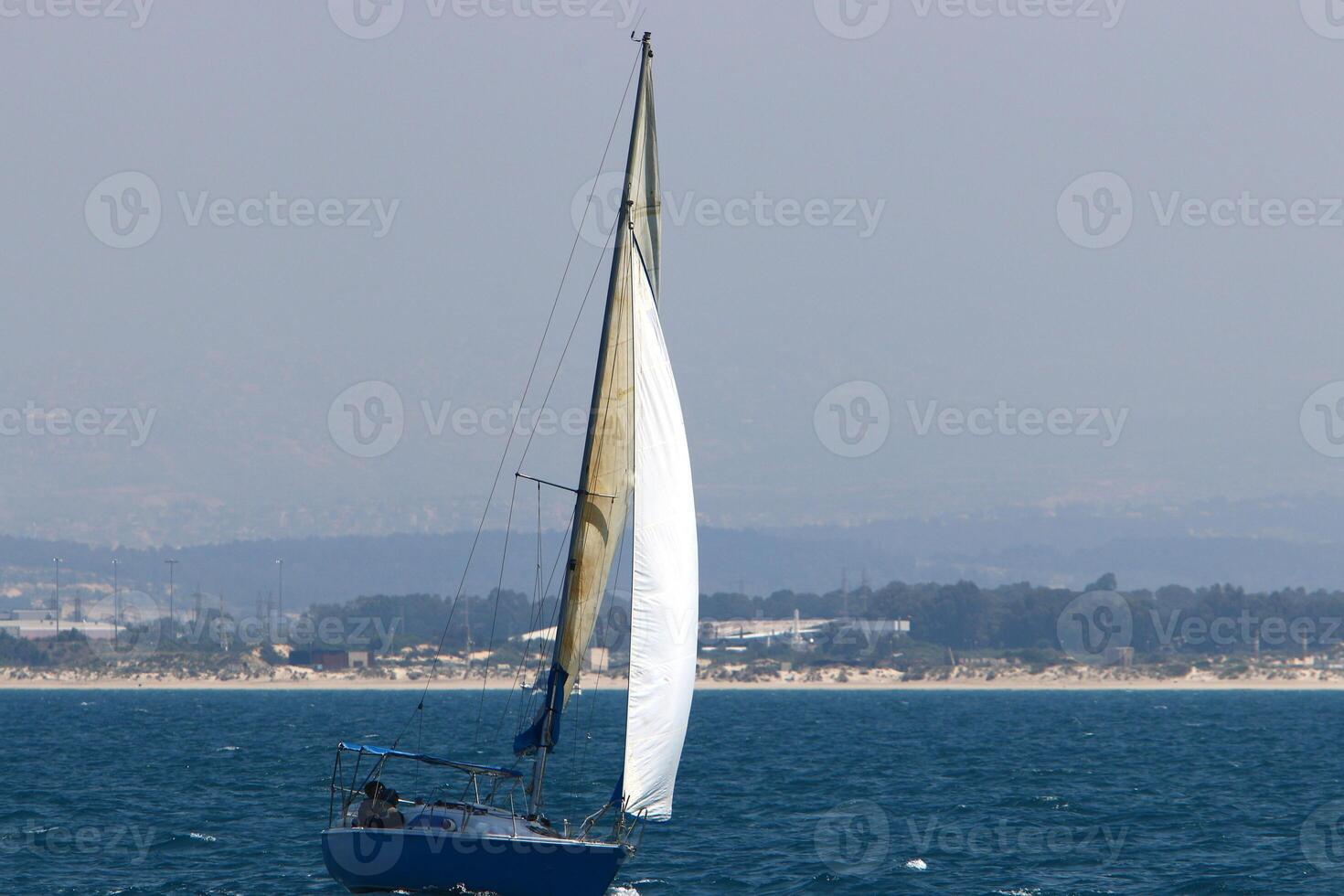 a yacht with a tall sail in the open sea photo