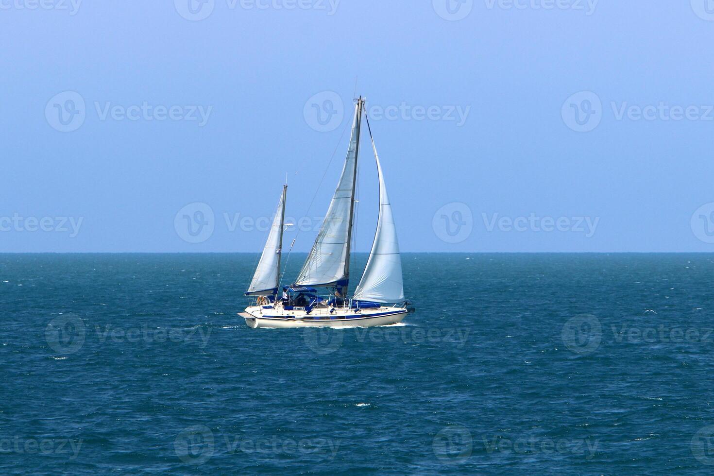 a yacht with a tall sail in the open sea photo