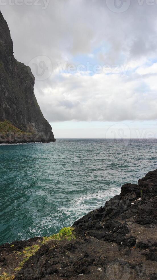 Seaside view with ocean waves crashing against rocky cliffs in Madeira, Portugal photo