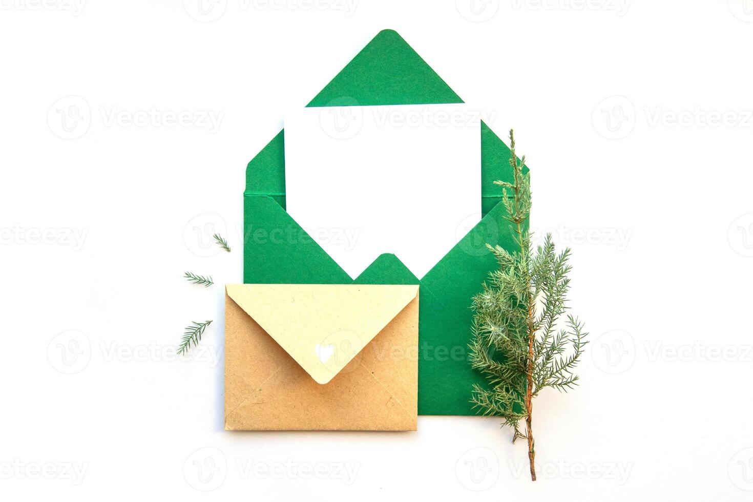 Crafting handmade envelopes and decorative elements with evergreen sprigs on a light backdrop during the holiday season photo