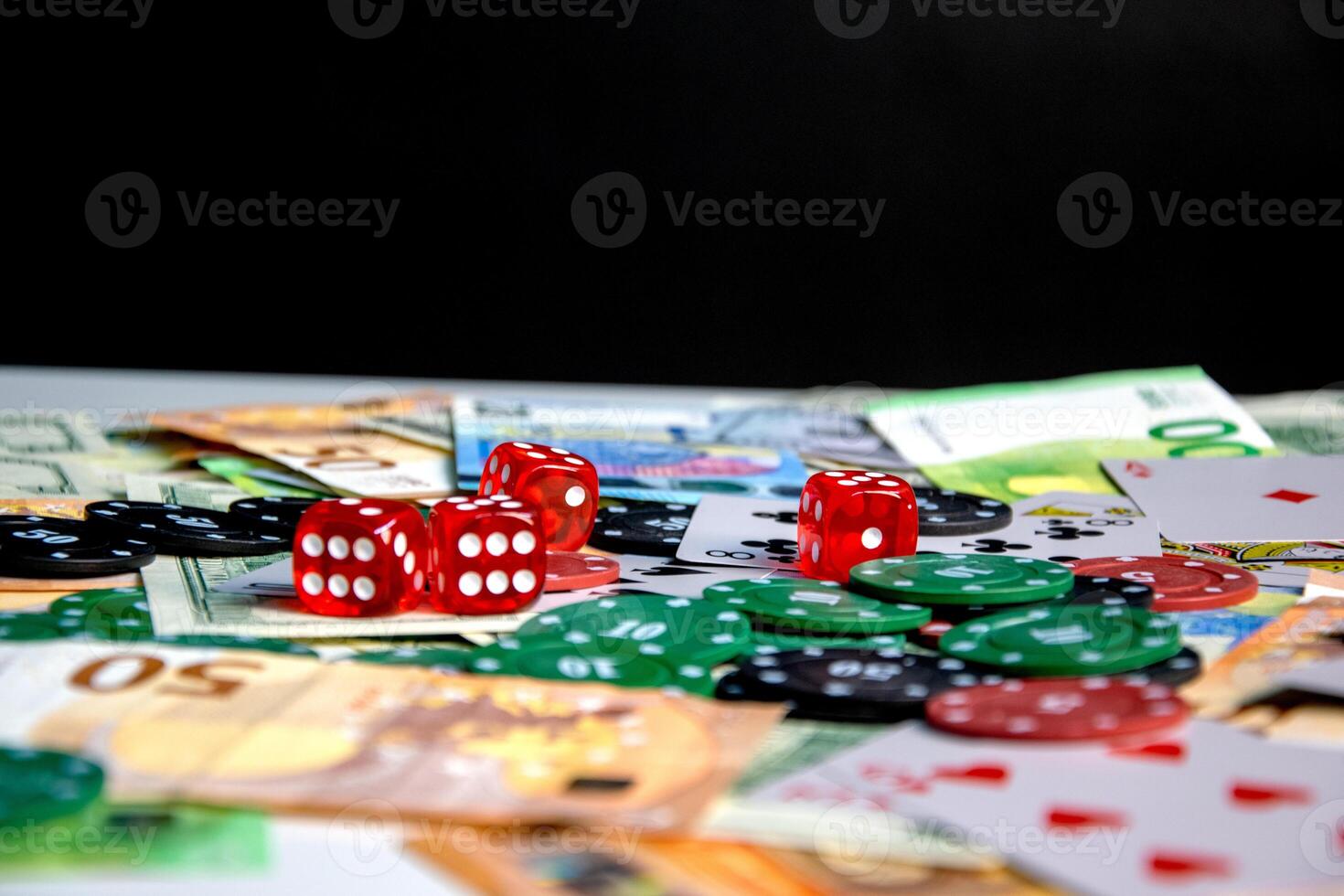 A close-up shot of a table with red dice, poker chips, and Euro banknotes scattered across the surface photo