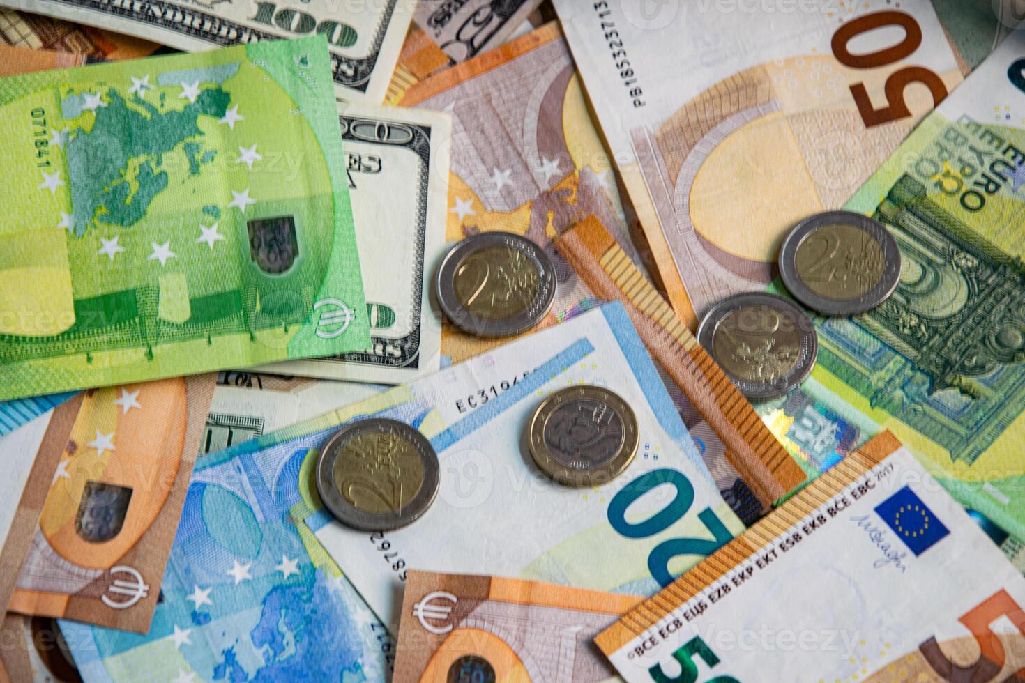 A close-up view of Euro and US dollar banknotes and coins scattered on a flat surface photo