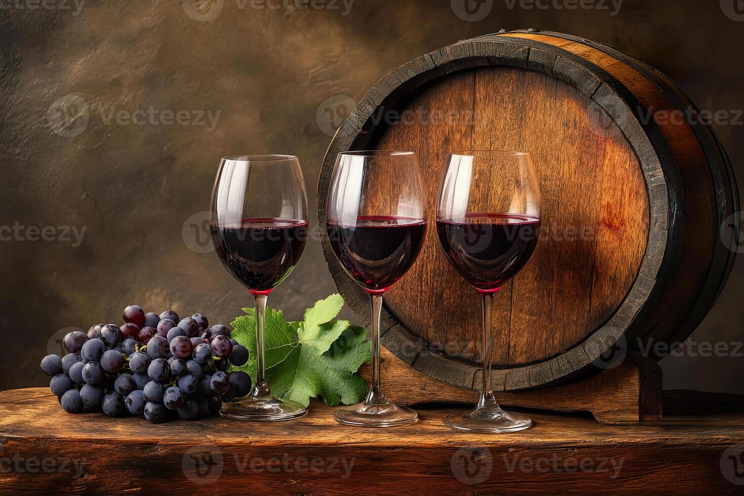 Three glasses of red wine accompany fresh grapes beside a wooden wine barrel photo