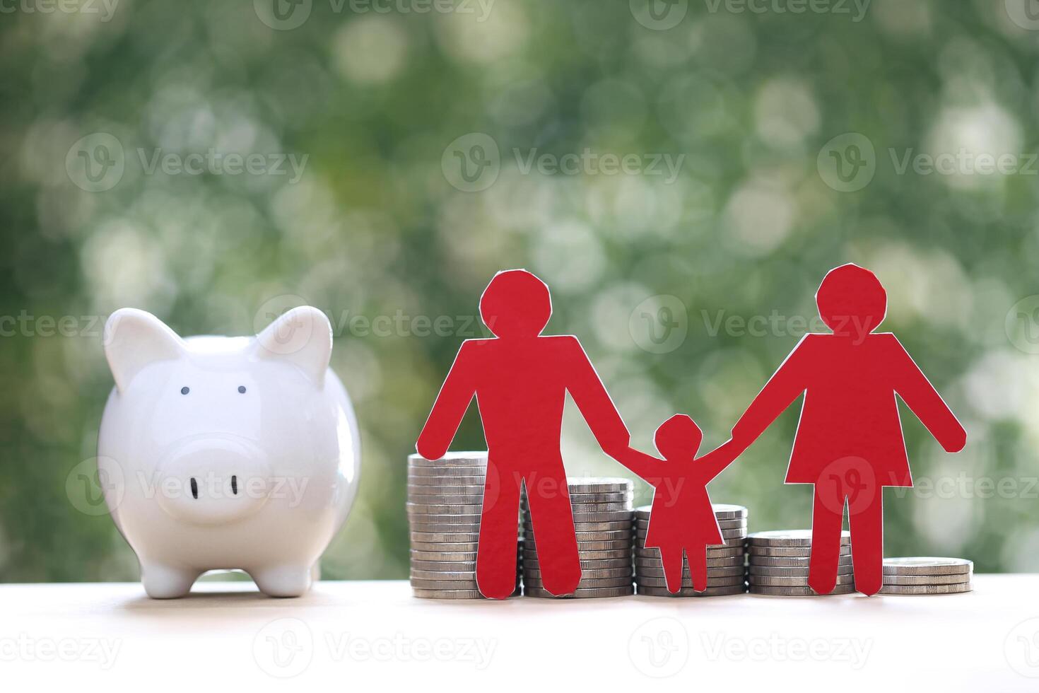 Model family with piggy bank and stack of coins money on natural green background,Save money for prepare in future and family finance concept photo