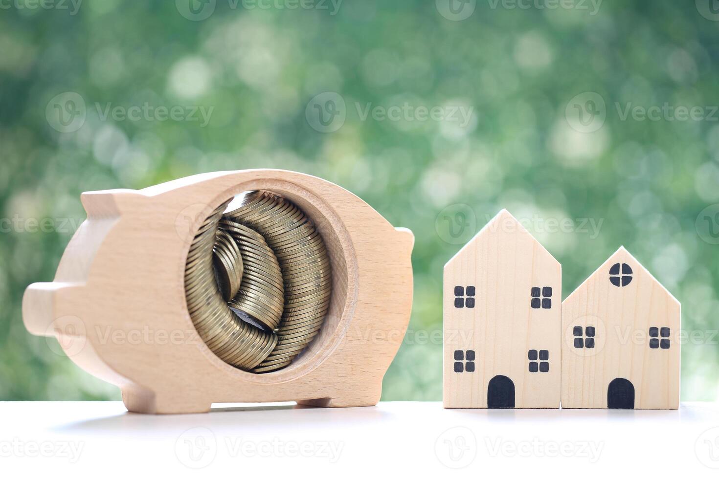 Finance, Model house with piggy bank and stack of coins money on natural green background,Business investment and real estate concept photo