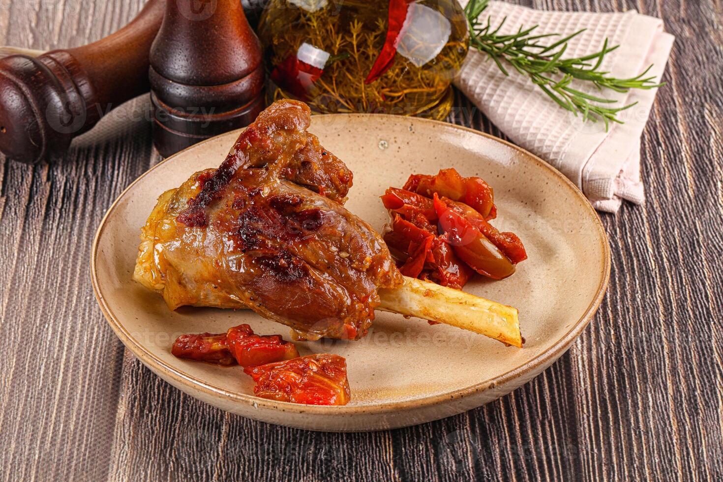 Baked lamb shank with vegetables photo
