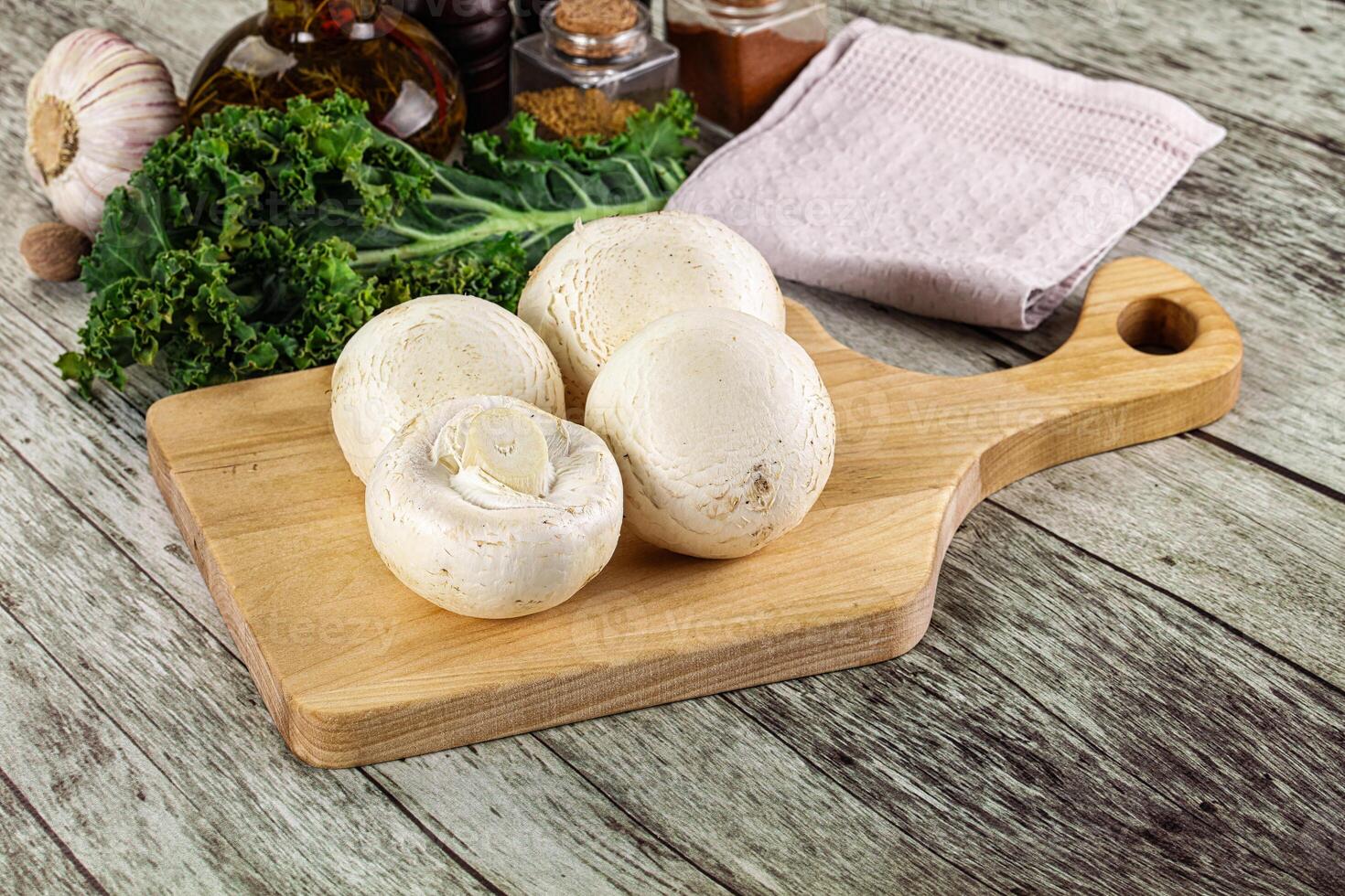 White champignon mushrooms heap over board photo