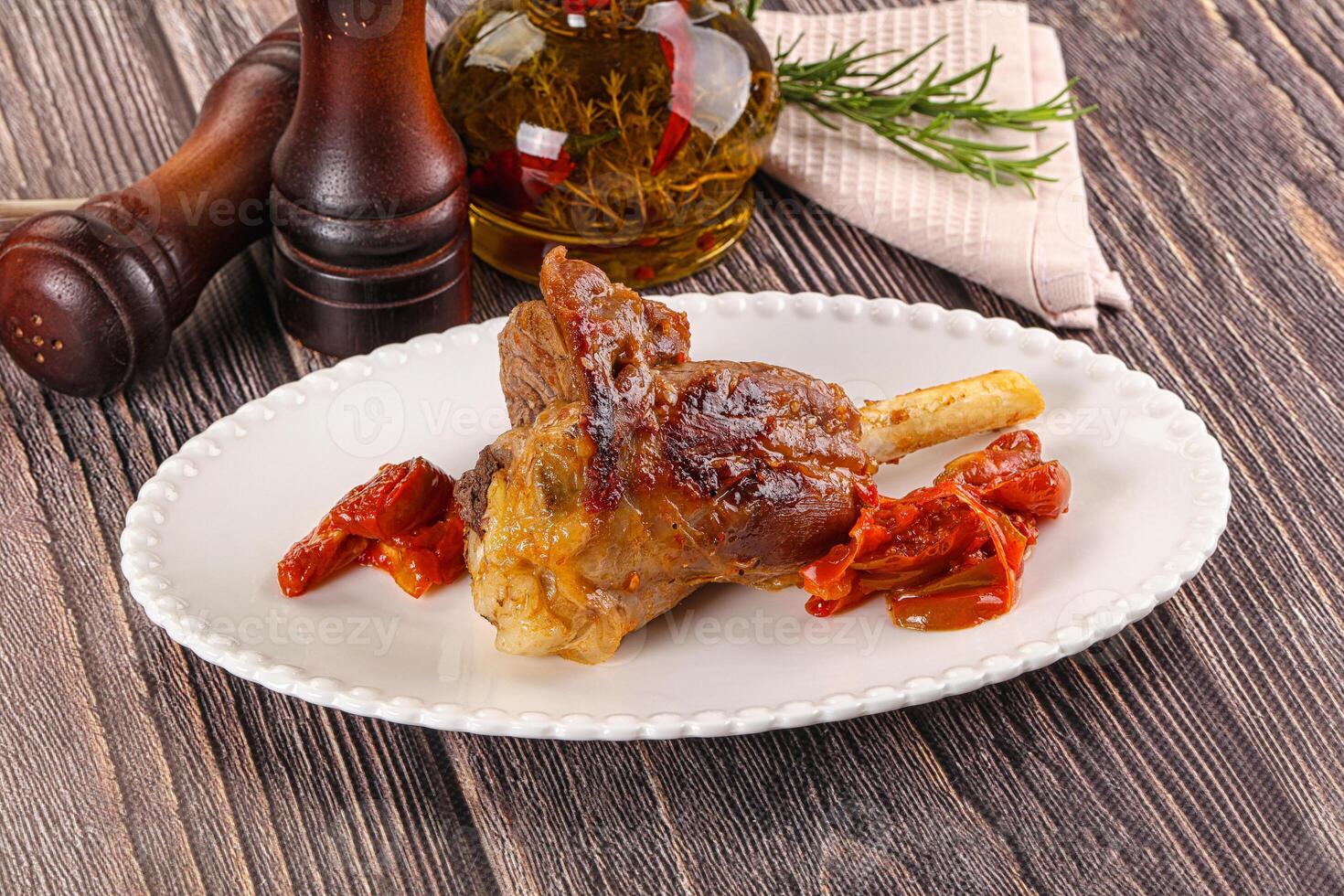 Baked lamb shank with vegetables photo
