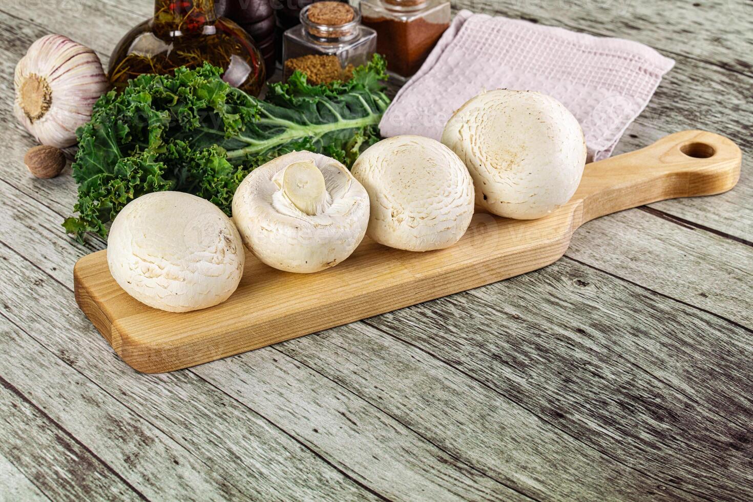 White champignon mushrooms heap over board photo