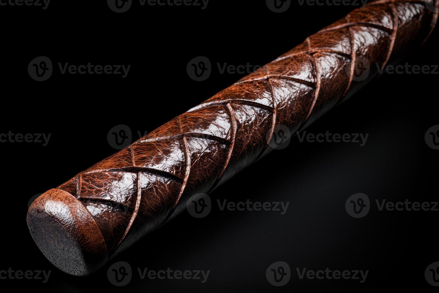 Close up of a braided leather whip on a dark background photo