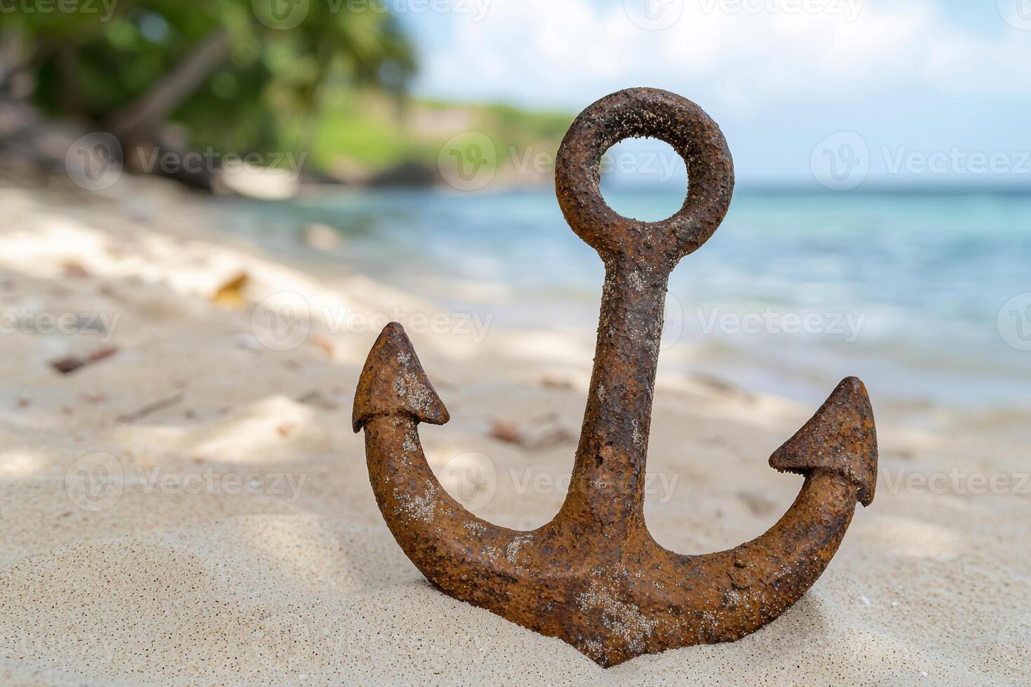 Rusty anchor on sandy beach photo
