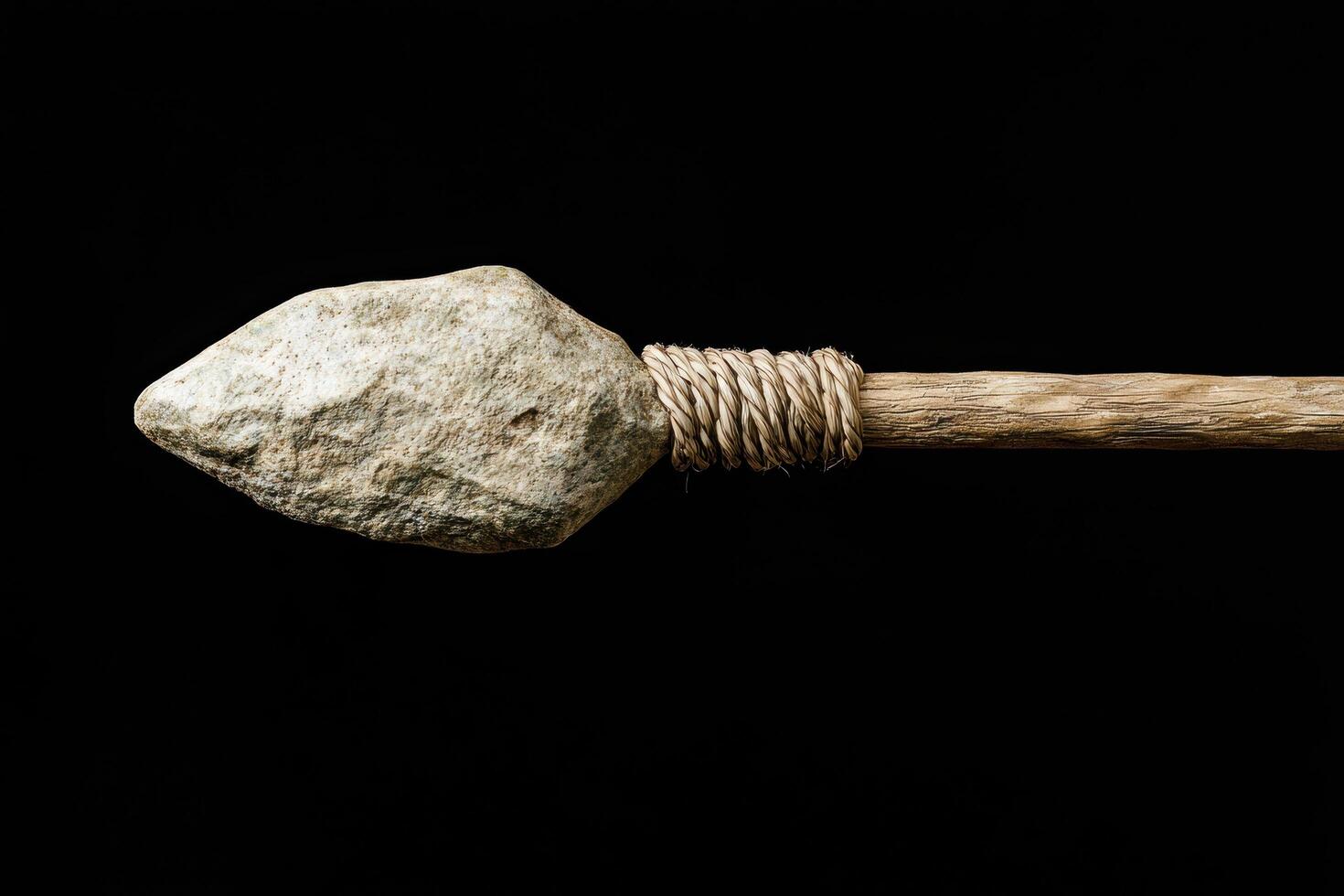 Primitive stone tool tied with rope on black background photo