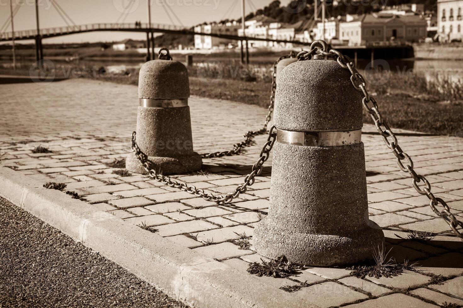 Stub posts linked in a chain on a quay photo