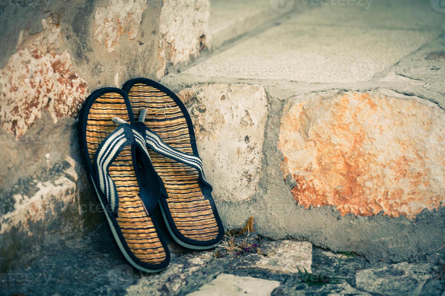 Beach flip-flops on the old wall background photo