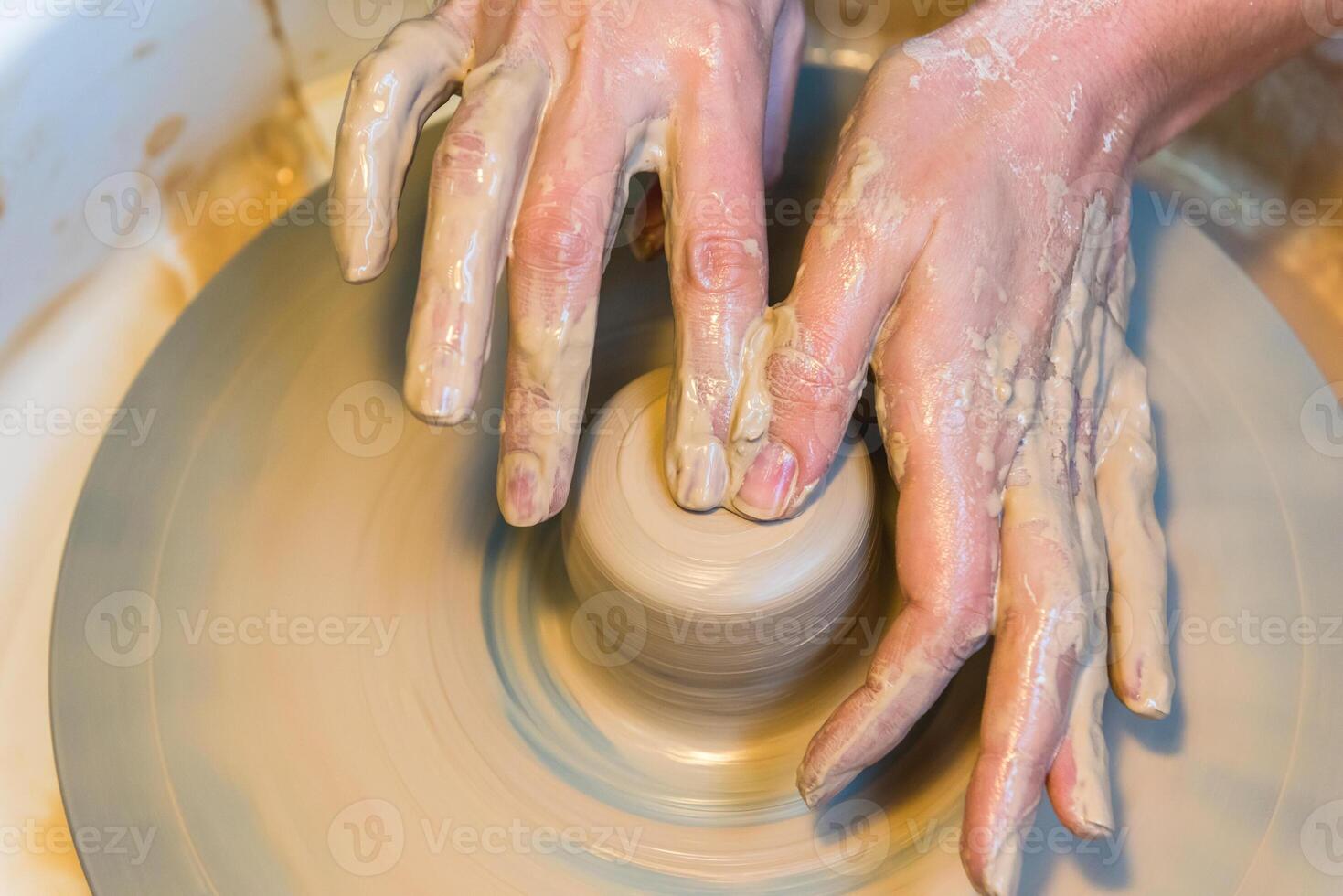 womens hands of a potter creating an earthen jar photo