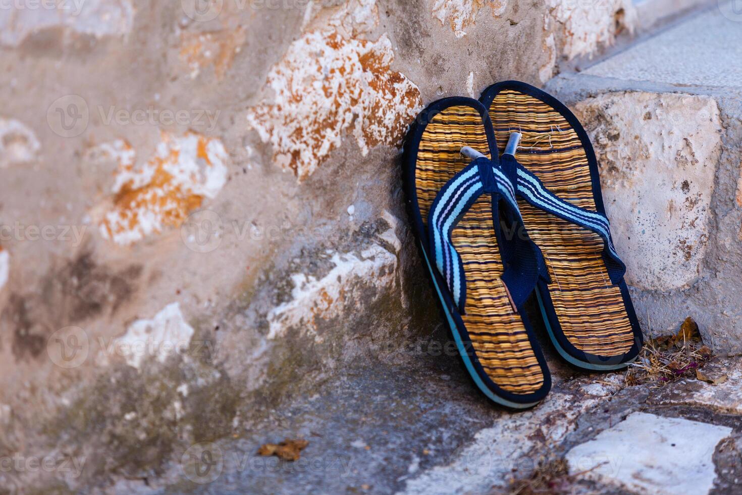 Beach flip-flops on the old wall background photo