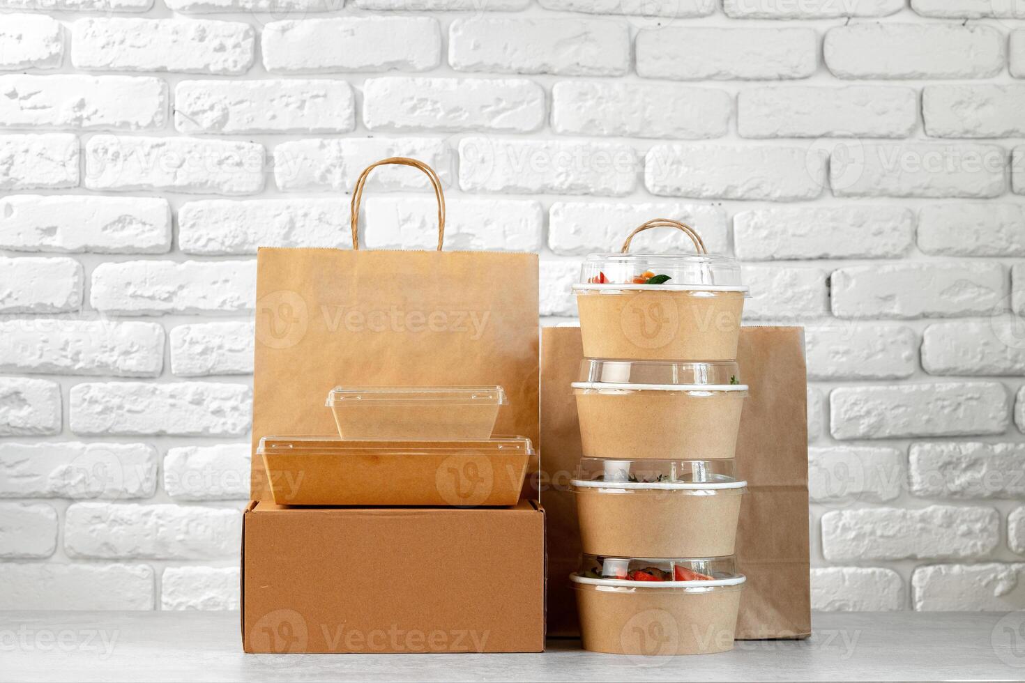 Take out food in boxes and craft bag against brick background photo