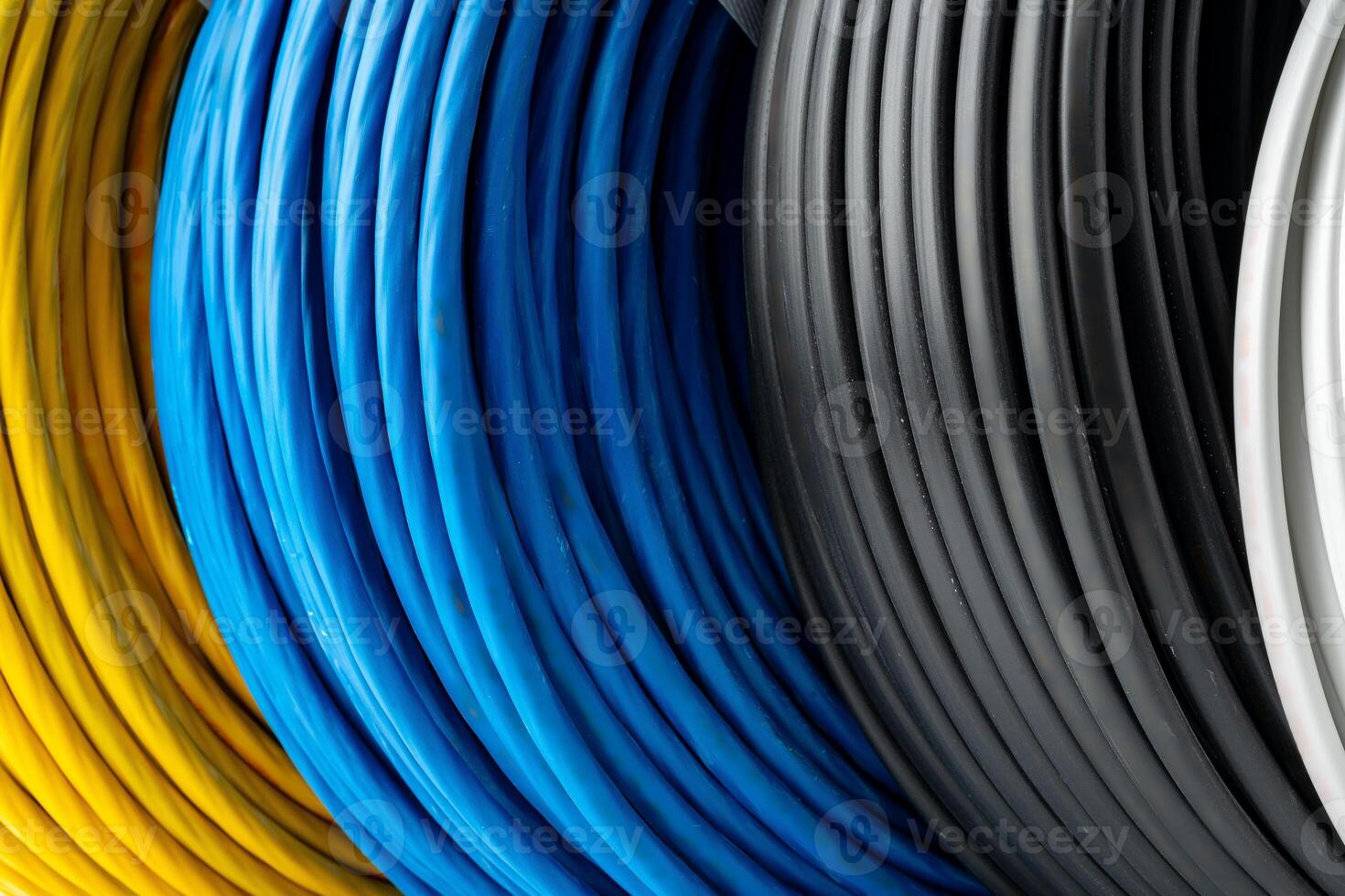 Four Spools of Electrical Wire in Yellow, Blue, Black, and White Colors. A Close-Up Photo of Four Spools of Electrical Wire, Each Wound in a Different Color.