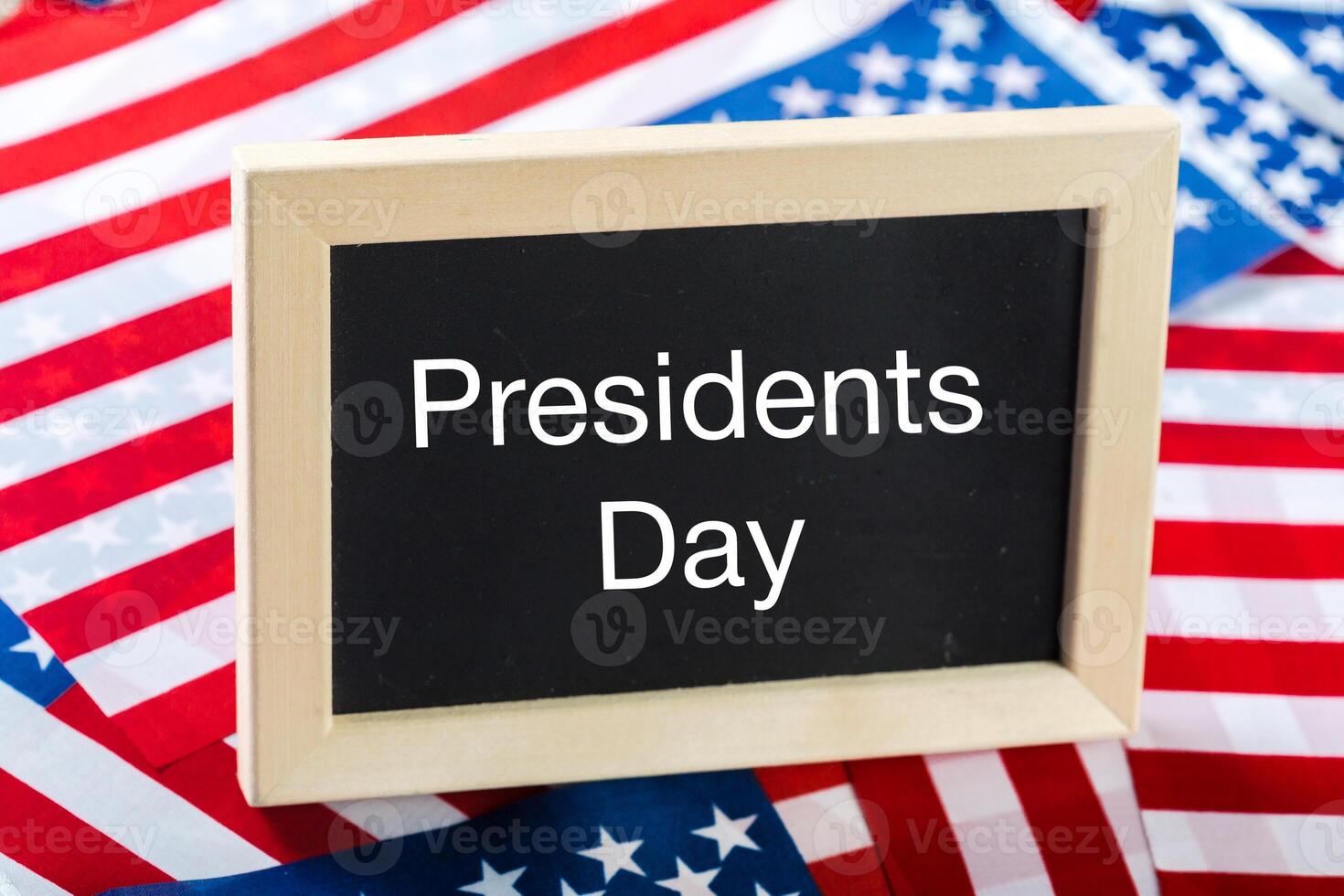 the text happy presidents day written in a chalkboard and a flag of the United States photo