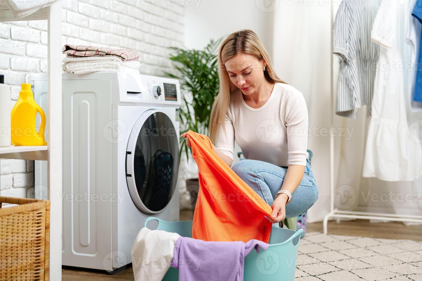 Woman Doing Laundry near a Washing Machine photo