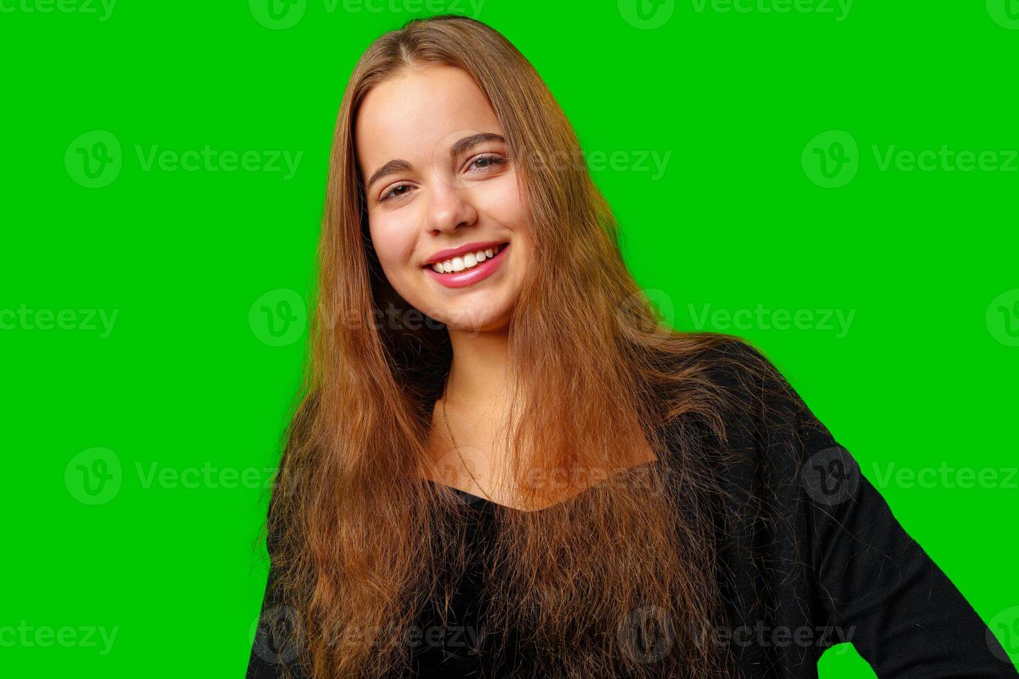 Young Woman With Long Hair Standing in Front of Green Screen photo