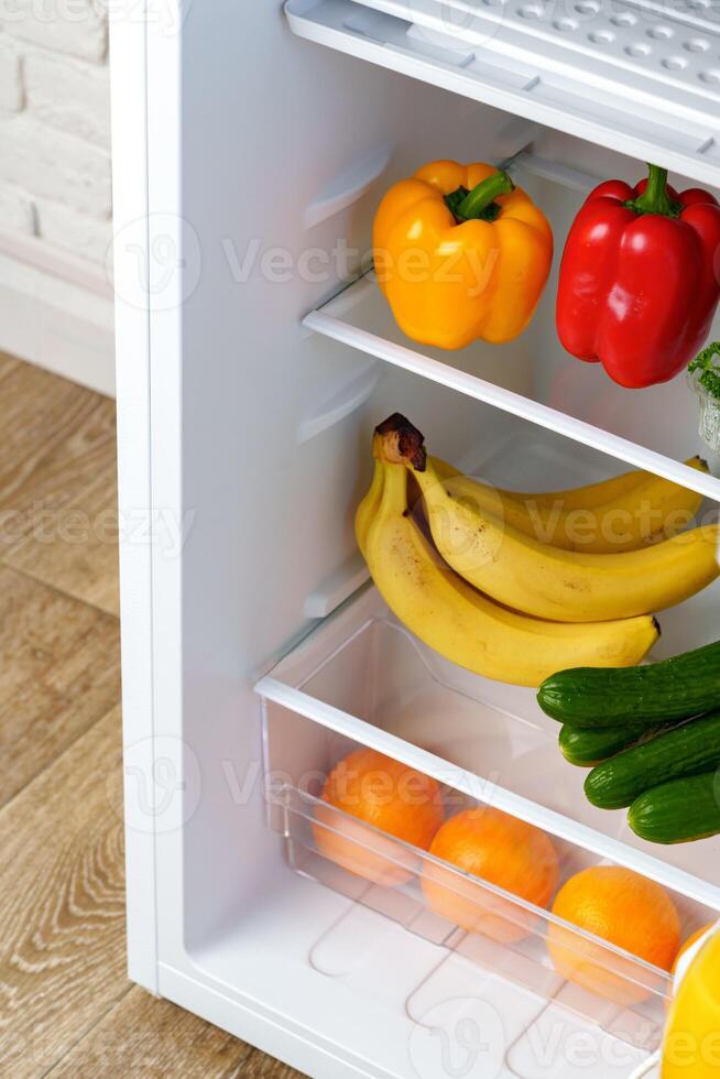 Open Refrigerator Door Showing Fresh Produce Inside photo