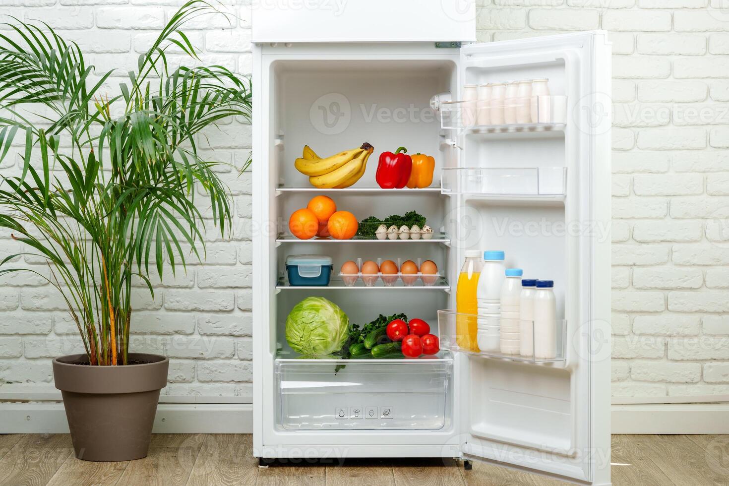 White Refrigerator Open With Fresh Produce and Dairy photo