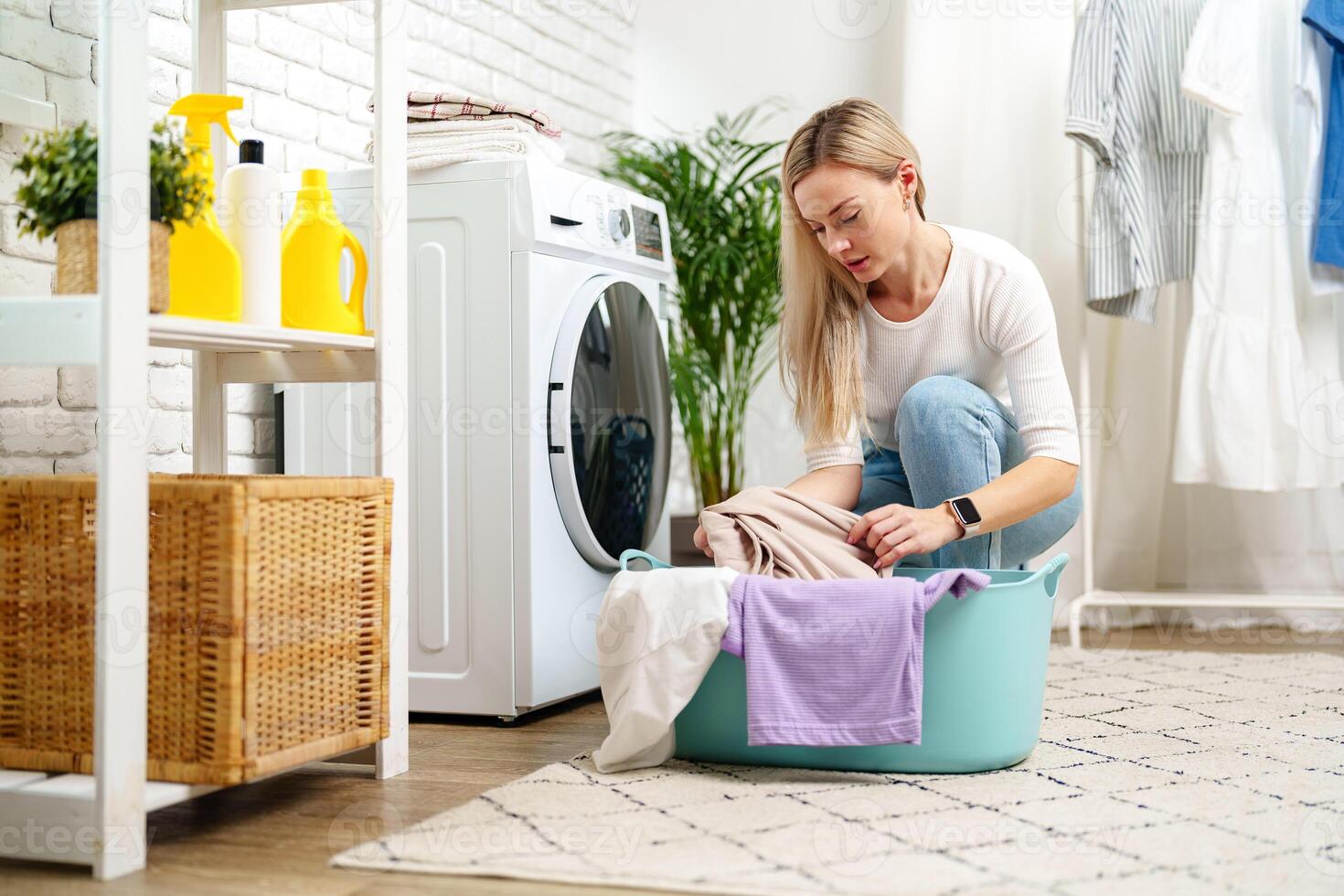 Woman Doing Laundry near a Washing Machine photo