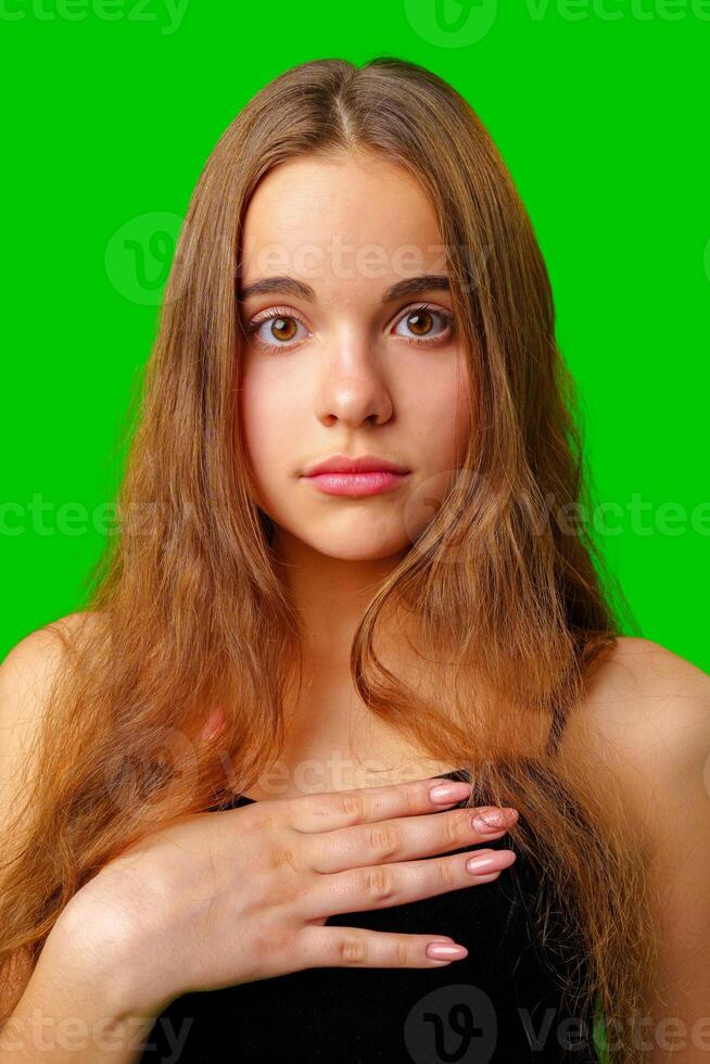 Young Woman Making a Surprised Face in Front of Green Screen photo