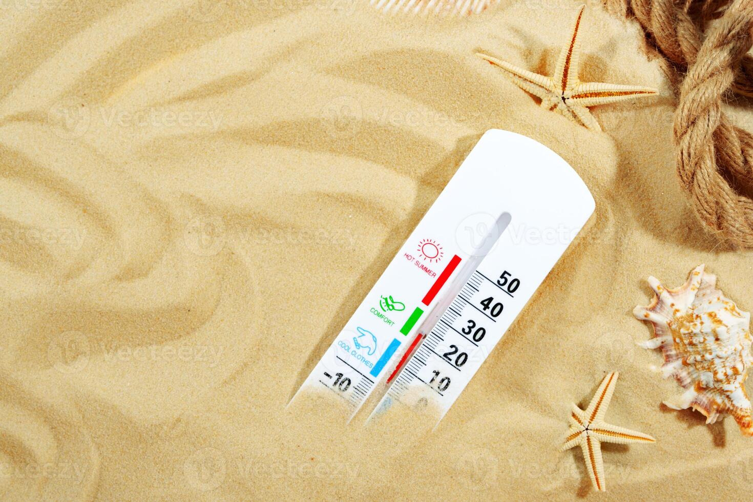 White Thermometer Measuring High Temperature on Sandy Beach With Starfish photo