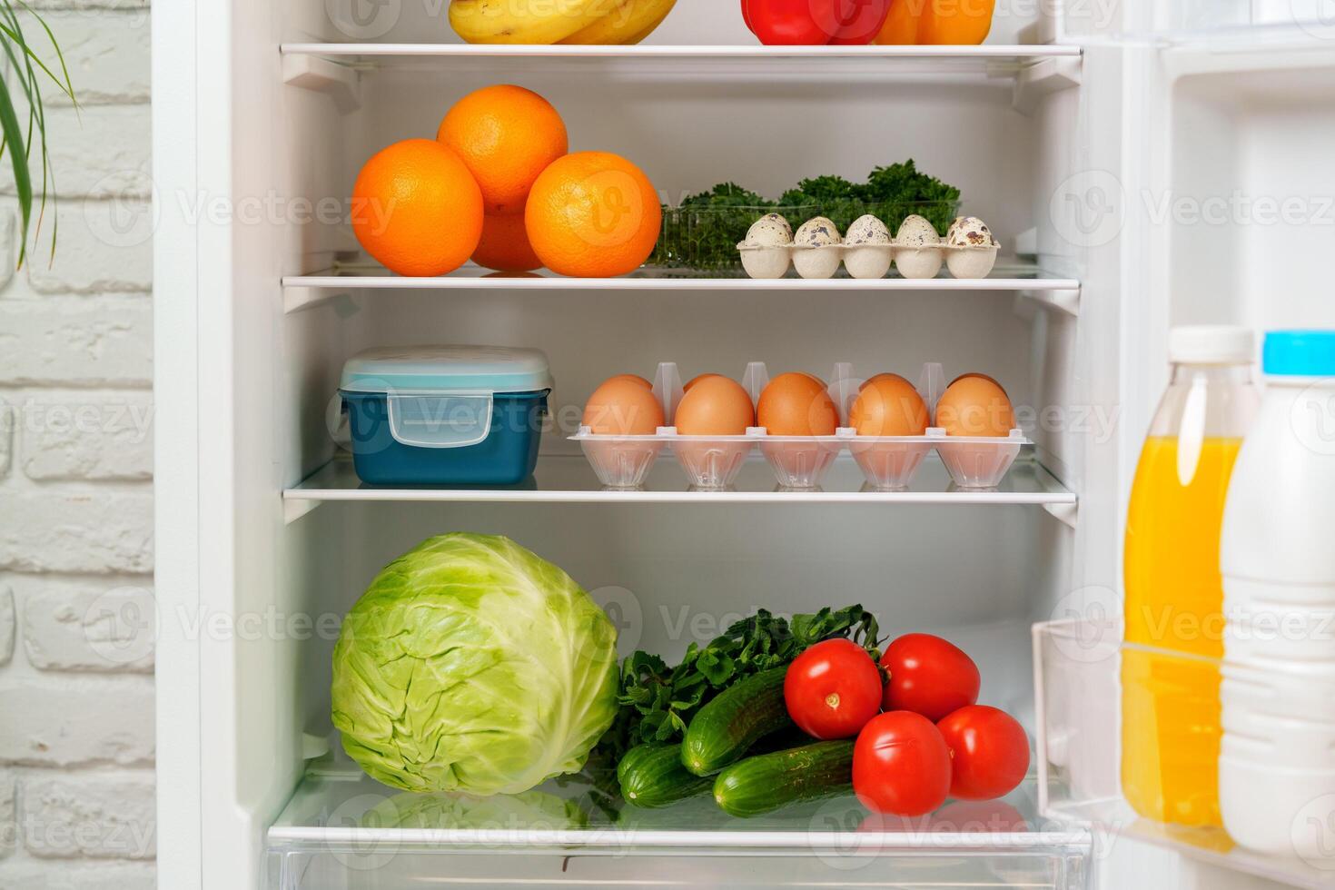 White Refrigerator Open With Fresh Produce and Dairy photo