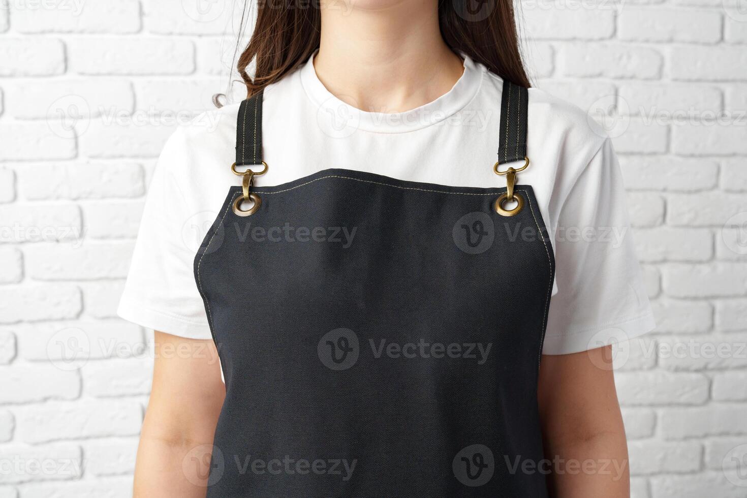 Black Apron With Pocket Worn by Person Standing In Front of White Brick Wall photo