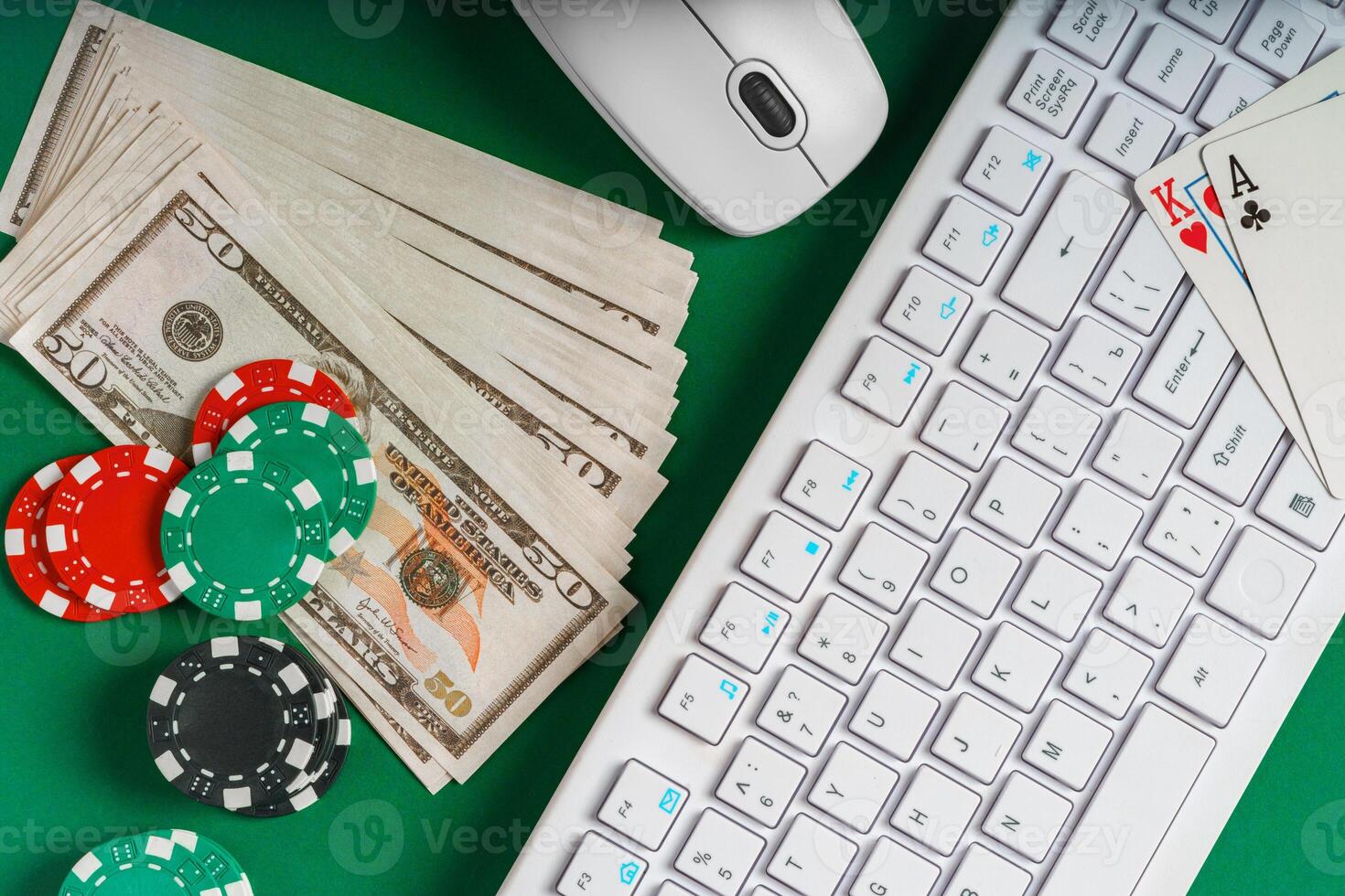 White Keyboard, Cash, Playing Cards, and Dice on Green Felt Table photo