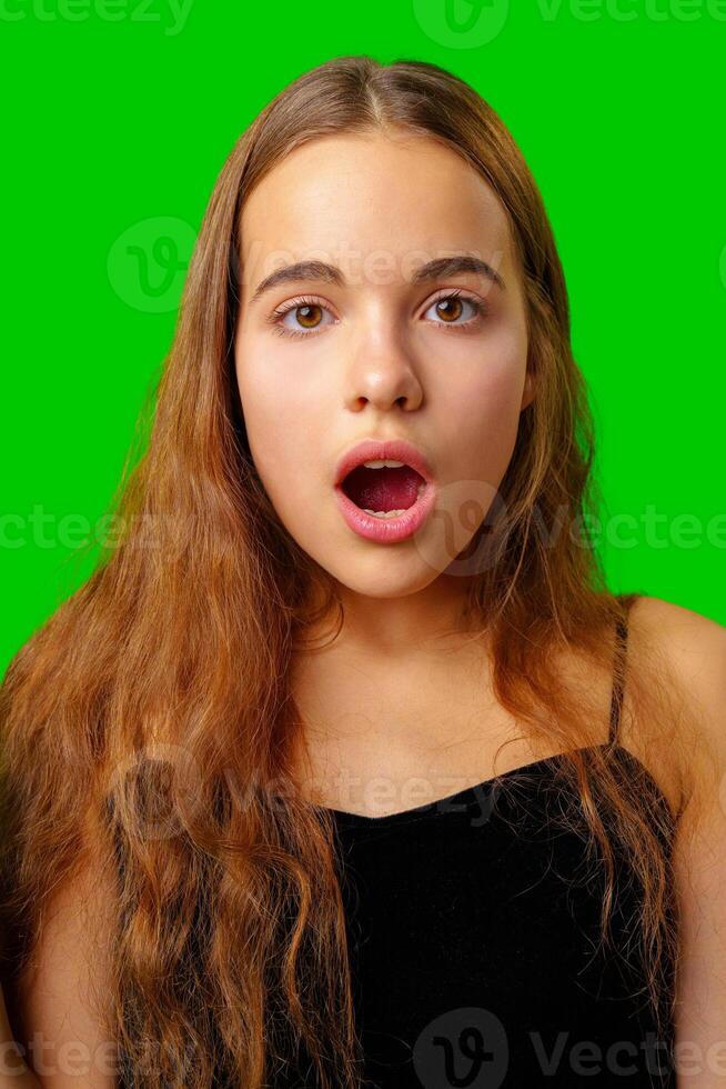 Young Woman Making a Surprised Face in Front of Green Screen photo