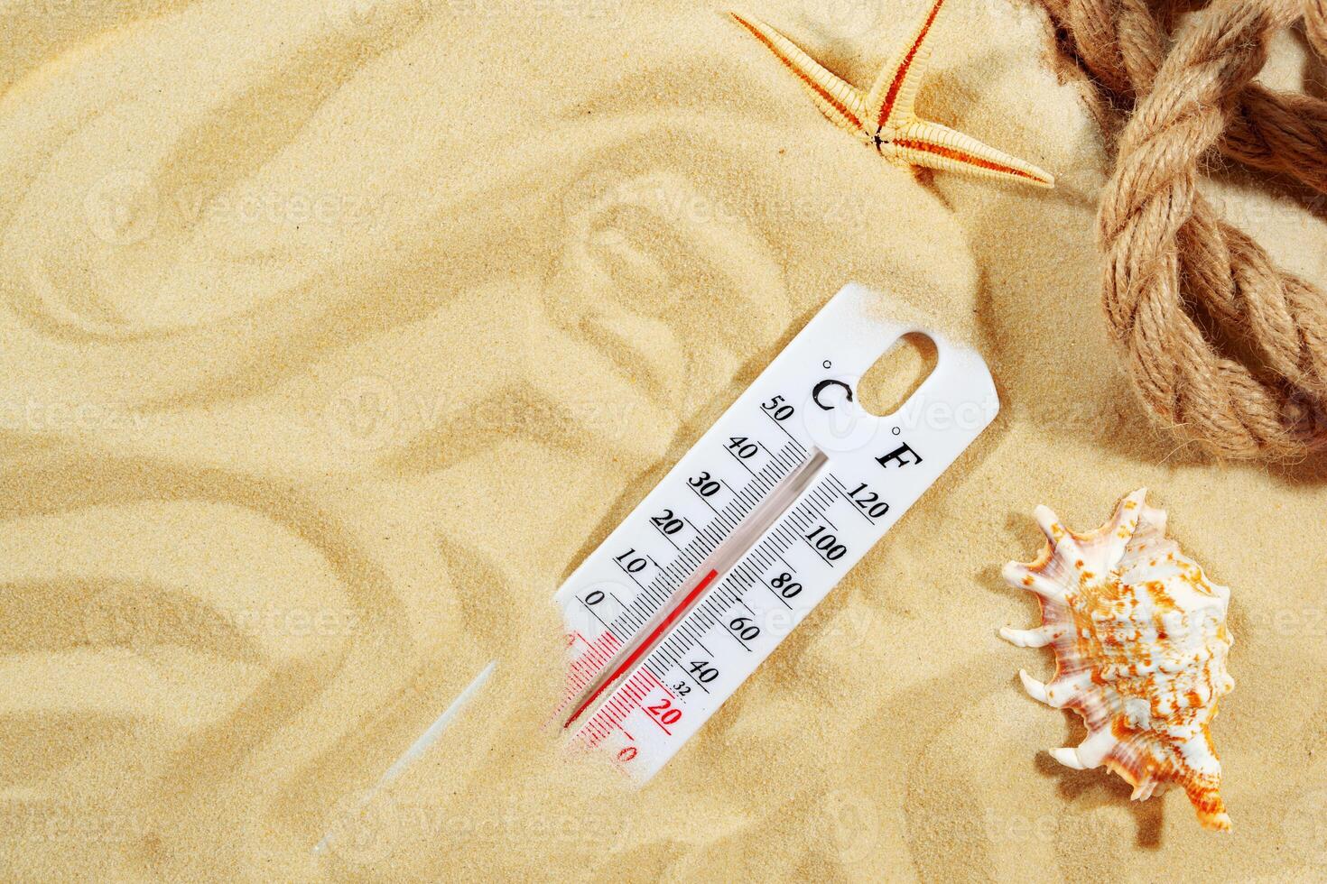 White Thermometer Measuring High Temperature on Sandy Beach With Starfish photo