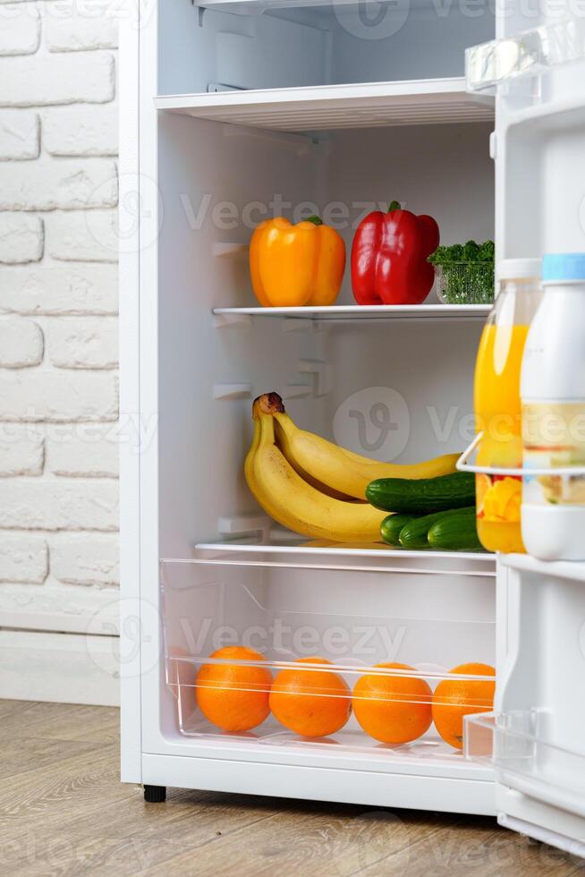 Open Refrigerator Door Showing Fresh Produce Inside photo