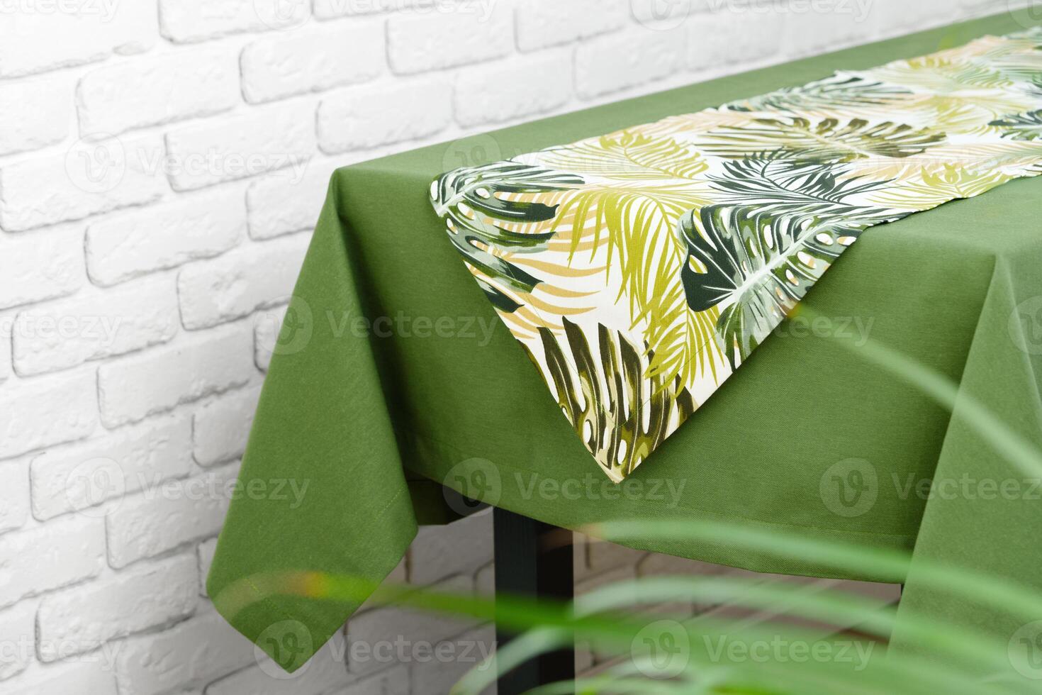 Green Tablecloth With Tropical Leaf Pattern Runner photo