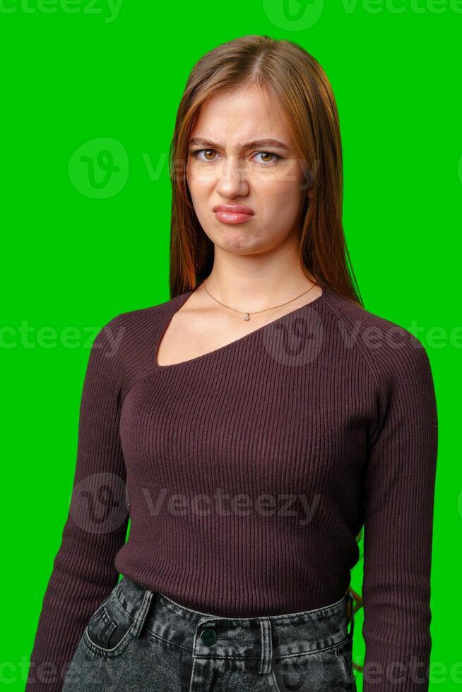 Young Woman With Disgruntled Expression Against Green Screen photo