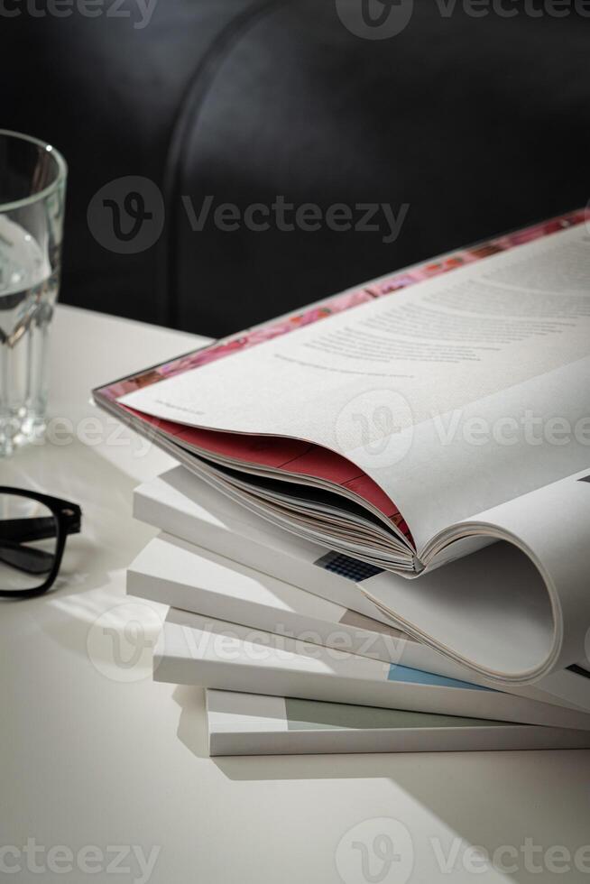 Stack of White Paperbacks and Glass of Water on White Table photo