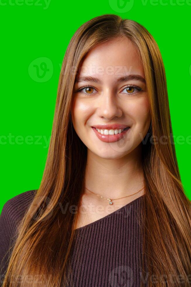 Smiling Young Woman With Long Brown Hair Against Green Screen photo