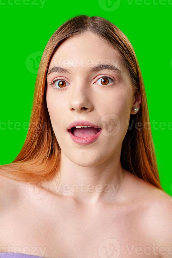 Young Woman With Surprised Expression in Front of Green Screen photo
