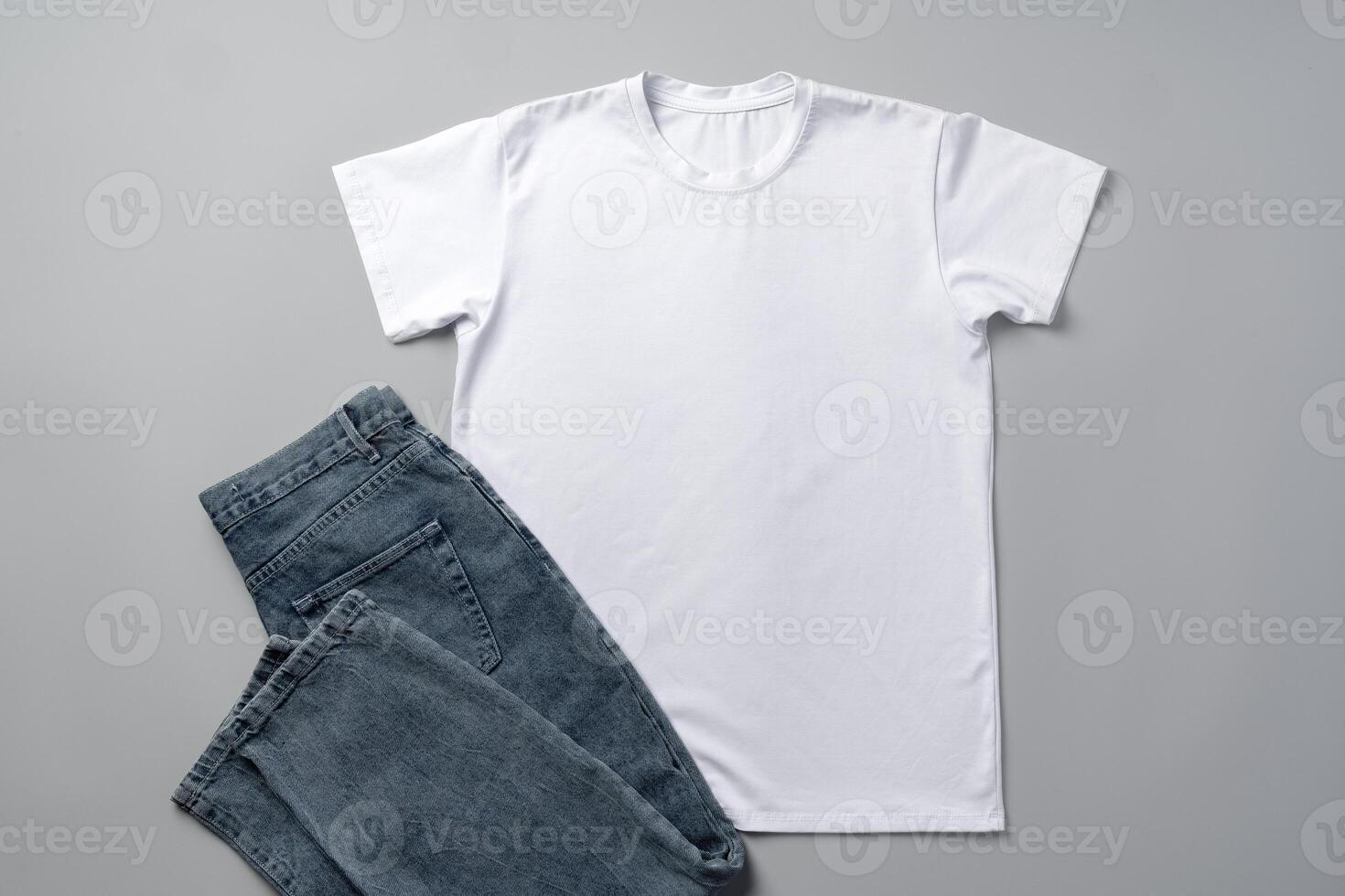 Cotton T-shirt and jeans on gray background top view photo