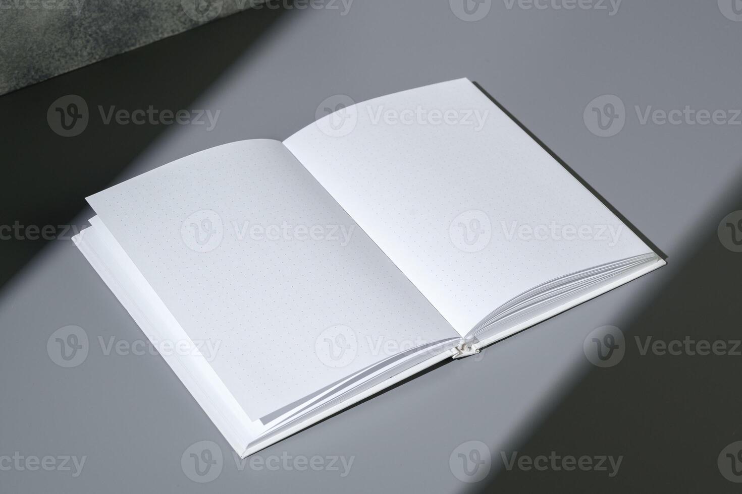 Blank open notepad on gray background studio shot photo