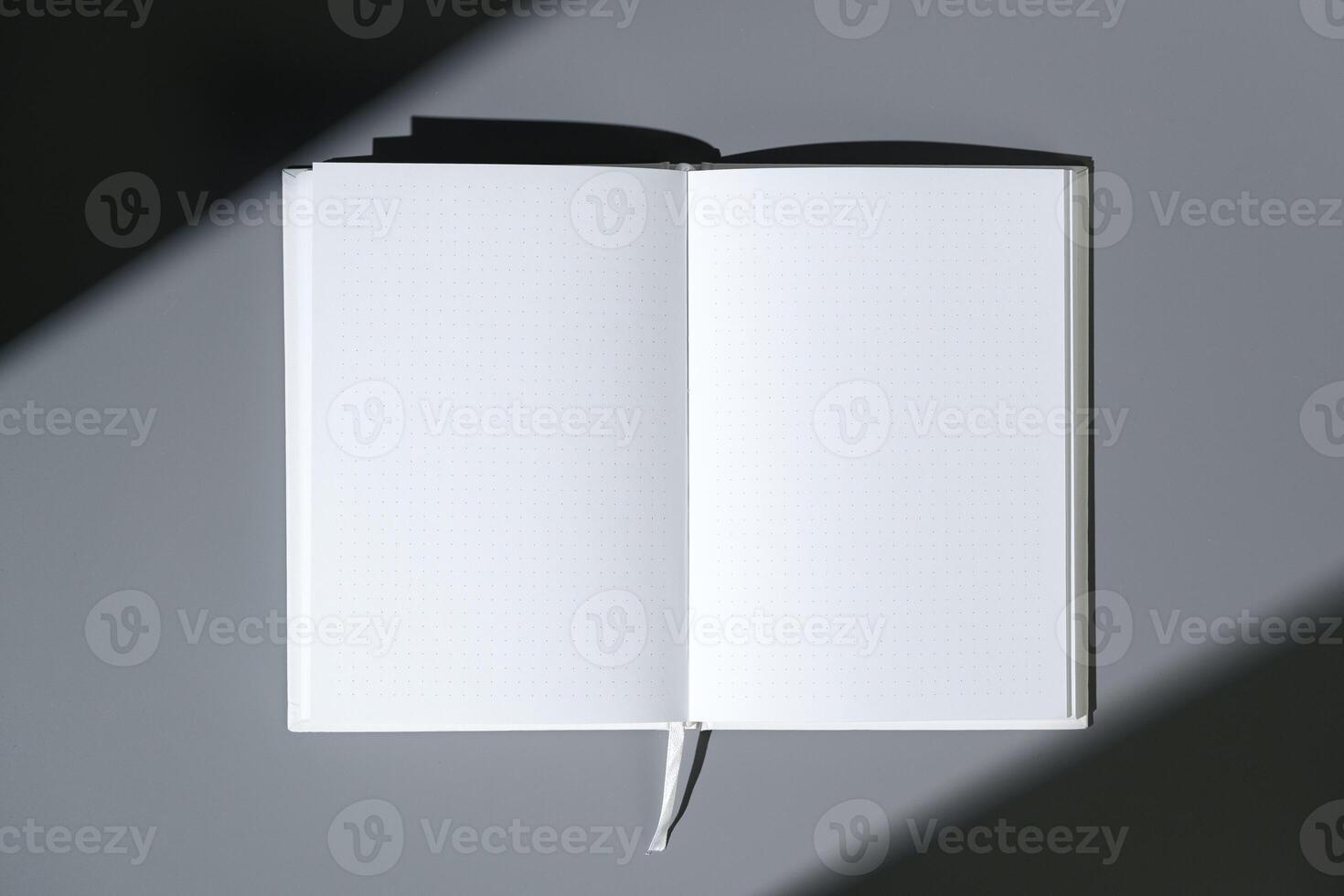 Blank open notepad on gray background studio shot photo