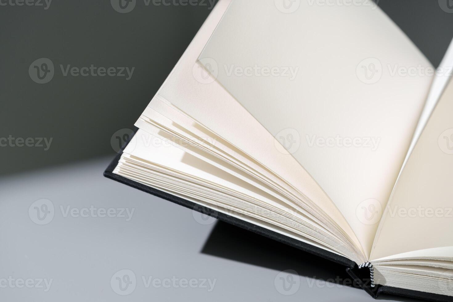 Blank open notepad on gray background studio shot photo