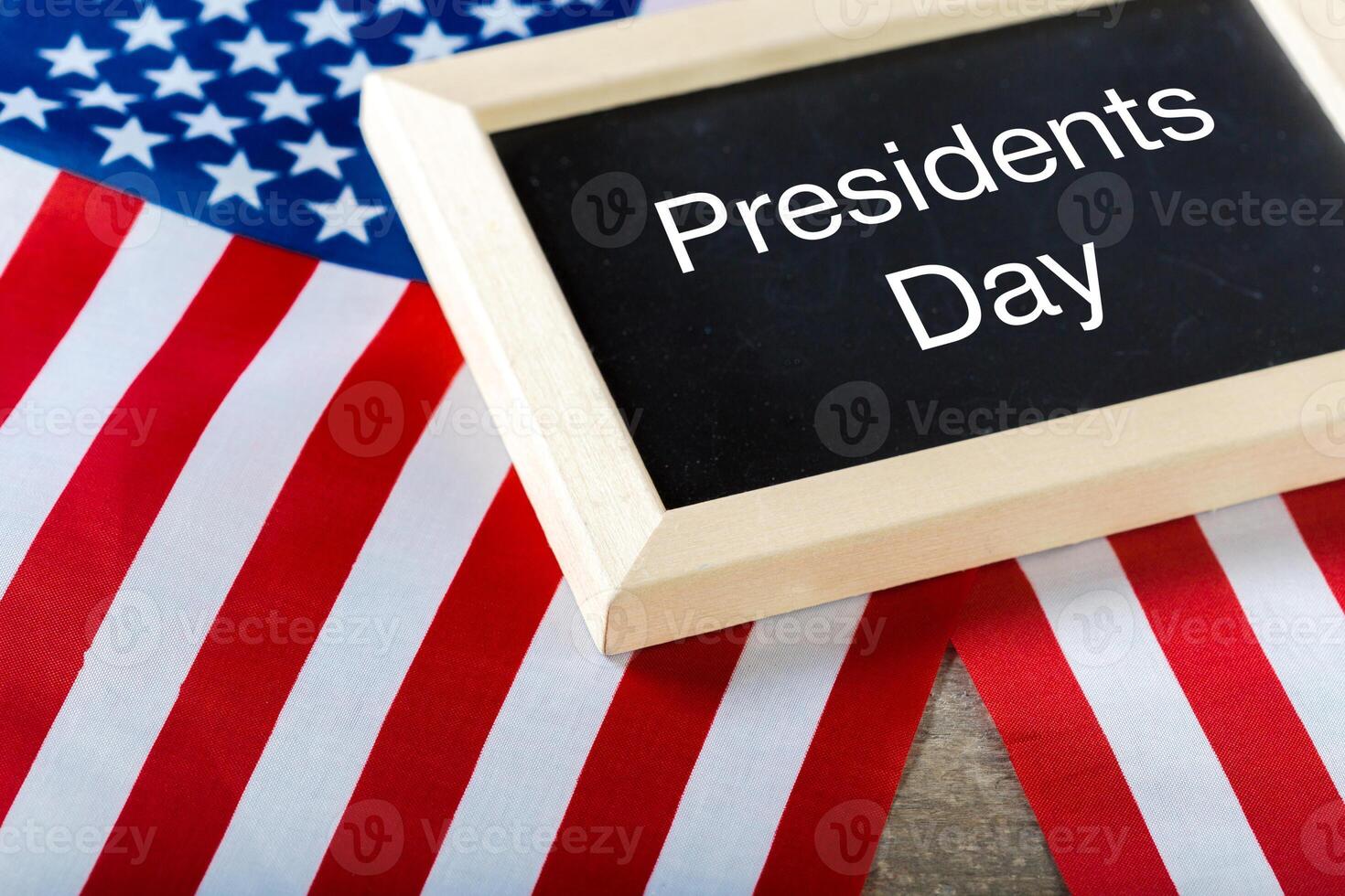 the text happy presidents day written in a chalkboard and a flag of the United States photo