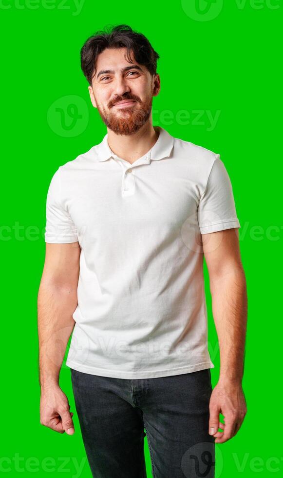 Young man with a beard smiling while standing against a bright green background photo